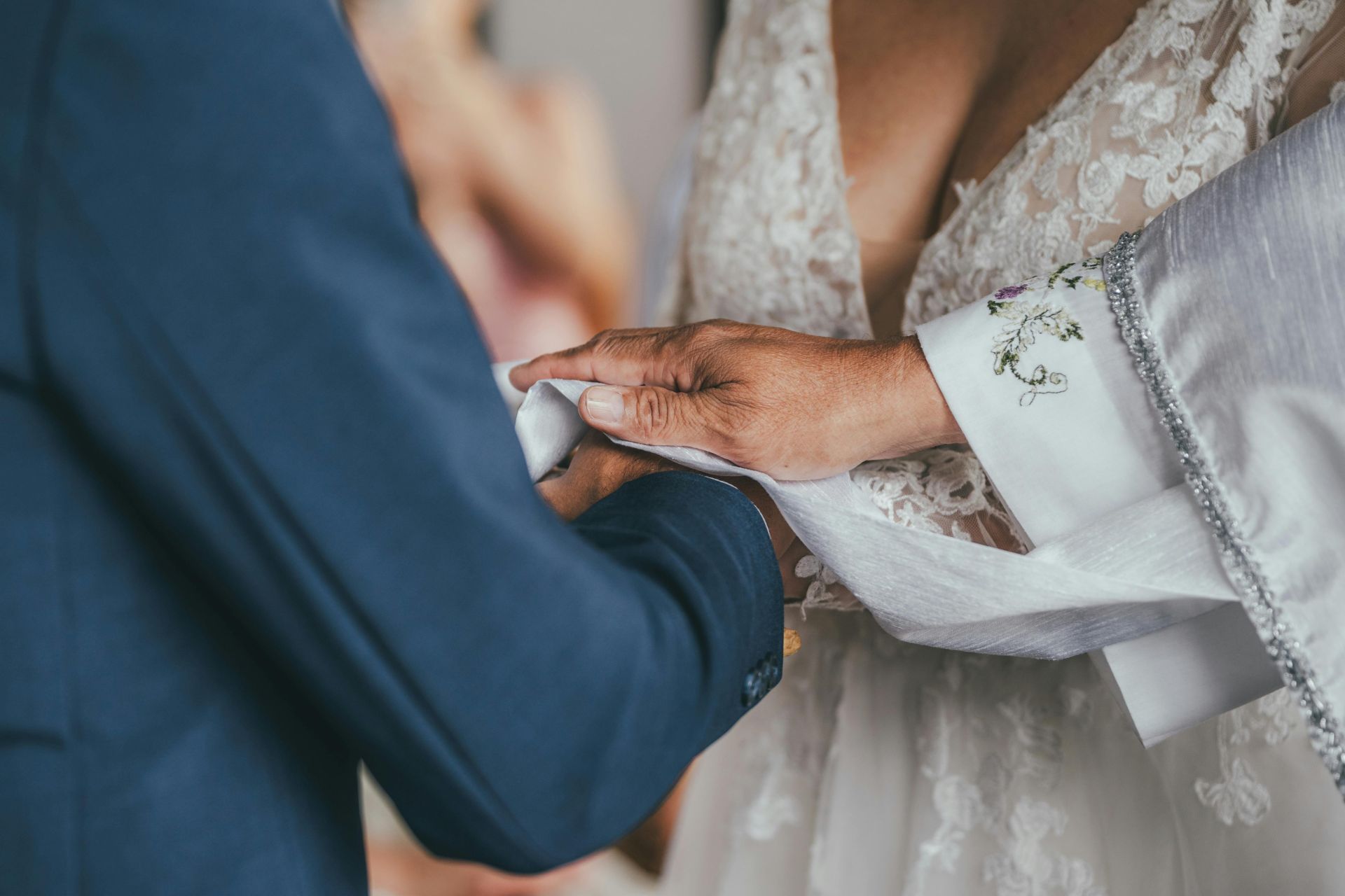 Close-up of a wedding ceremony handfasting ritual, symbolizing unity and commitment.